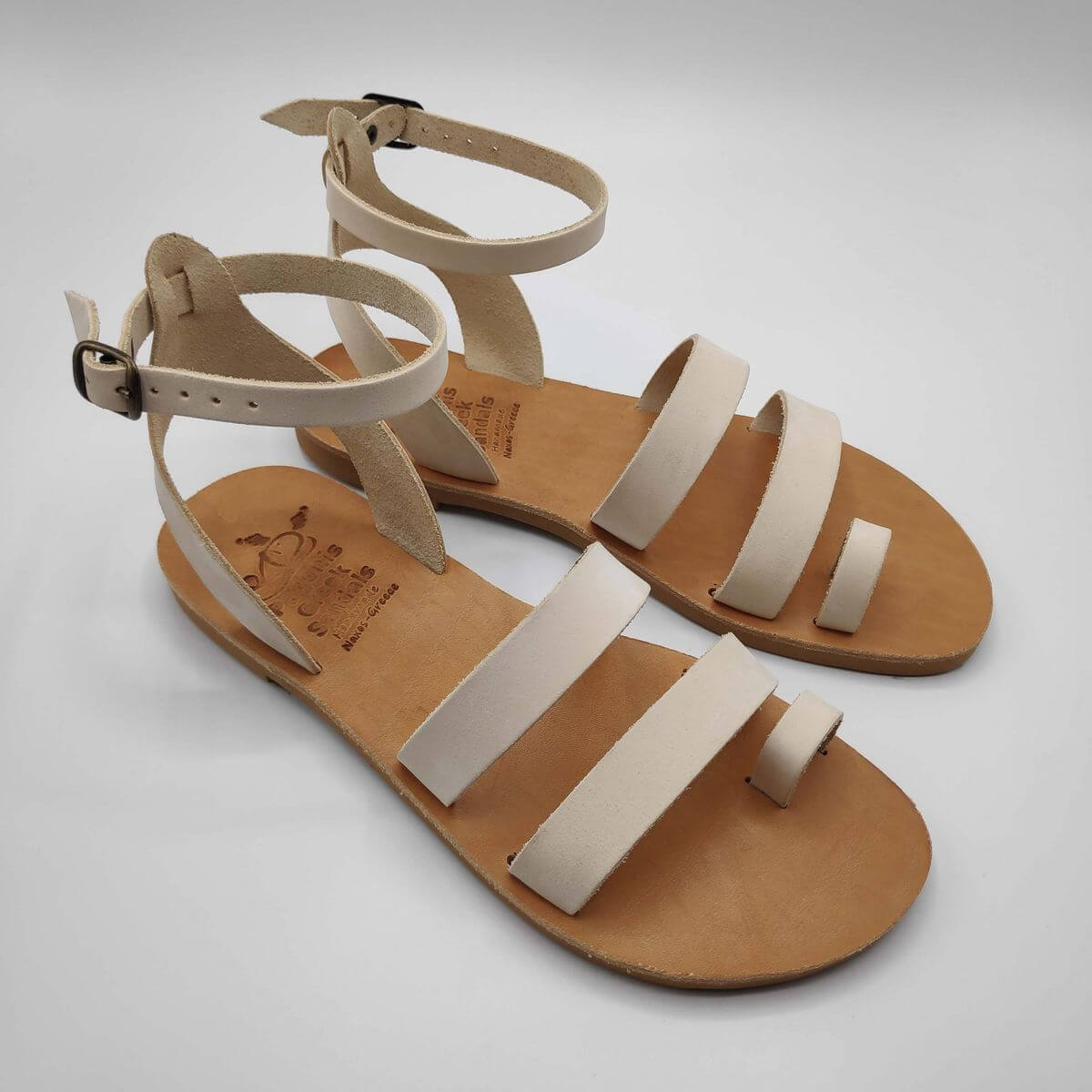 White nubuck leather dressy sandals with two straps, toe ring and high ankle strap, side view