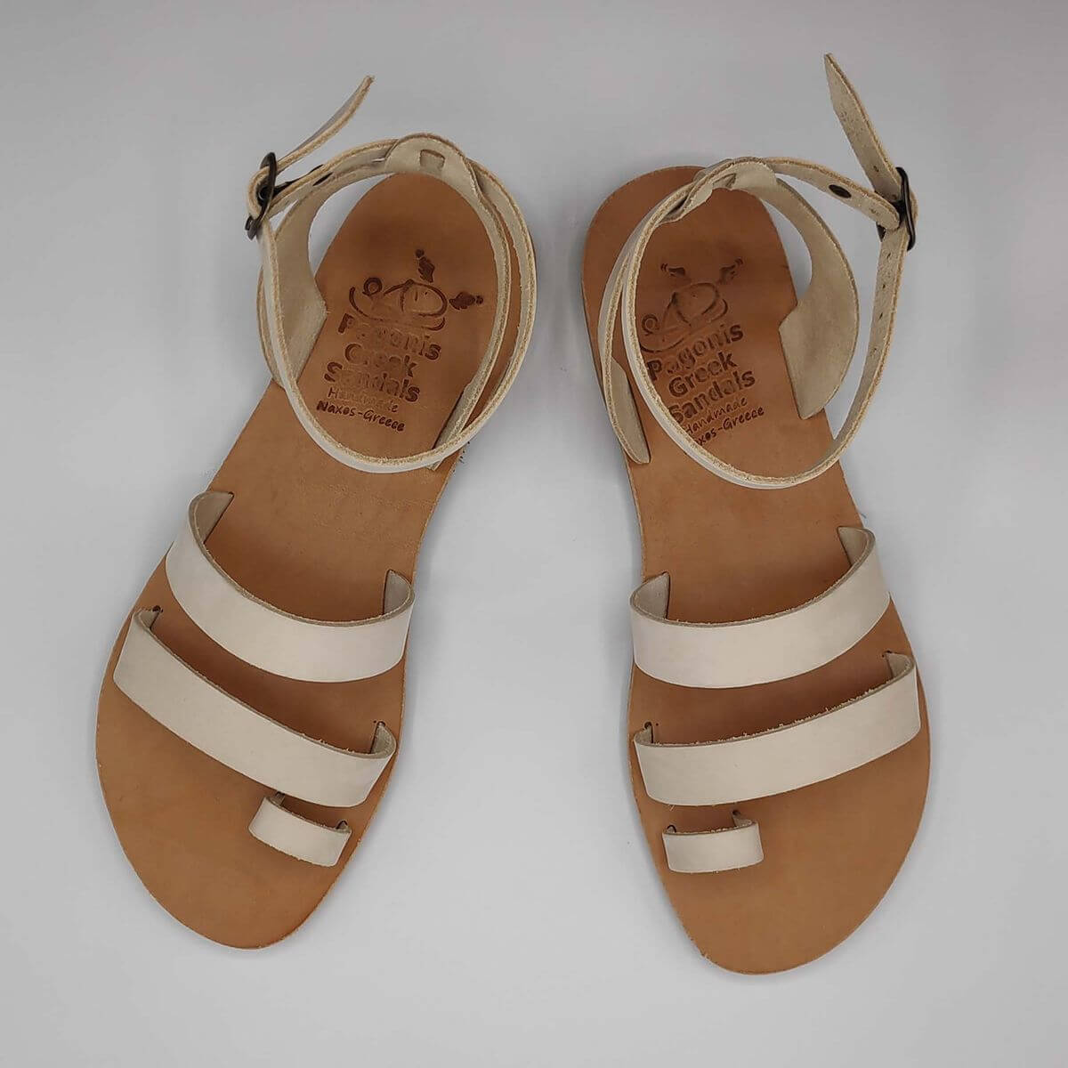 White nubuck leather dressy sandals with two straps, toe ring and high ankle strap, top view